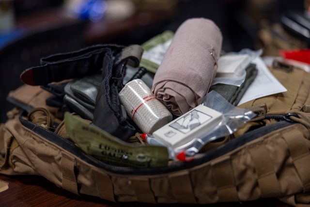 An open medical kit with bandages, tourniquets, and other first aid supplies.